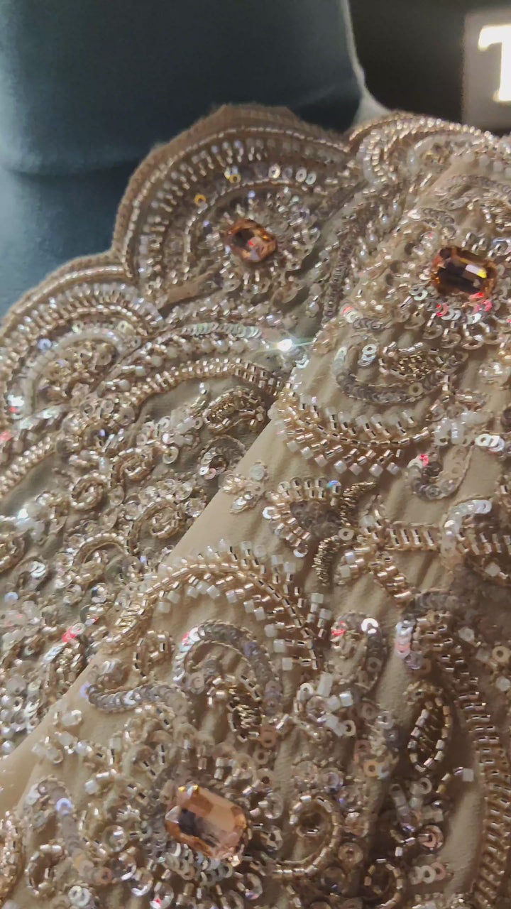 Ivory gold georgette saree adorned with intricate bead and sequin work.